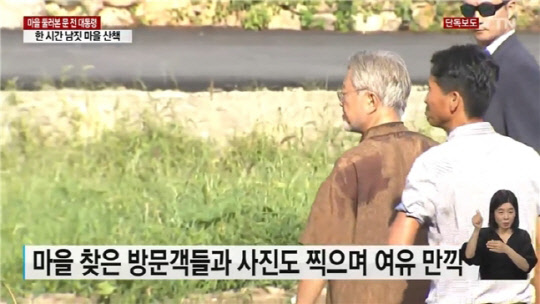 문재인 전 대통령이 지난 22일 양산 평산마을을 찾은 방문객들과 사진을 찍고 있다. 이날 경호구역 확대로 사저 인근이 조용해지자 문 전 대통령은 1시간 가량 마을 나들이에 나섰다. <YTN 방송화면>